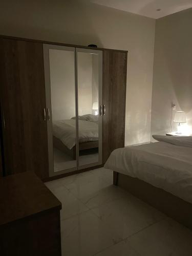 1 dormitorio con 1 cama y vestidor con espejo en الجود مخيم شقة استراحة بيت en Khamis Mushayt