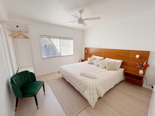 Norah50 meters to the beach Hargraves Beach Cottage的一间卧室，有一张床和一把绿色椅子