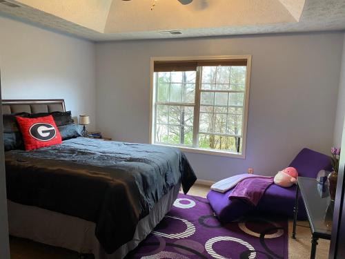 1 dormitorio con cama, ventana y alfombra morada en Happy Place en Conley