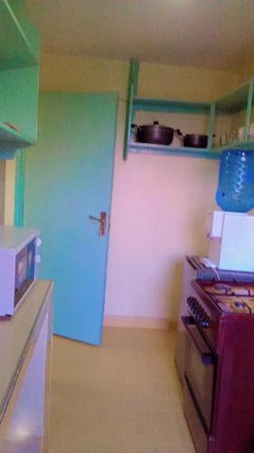cocina con puerta azul y fogones en NIKIFLATS en Nakuru