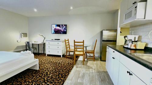 a kitchen with a bed and a table and chairs at Cloud 9 Inn in Whitecourt