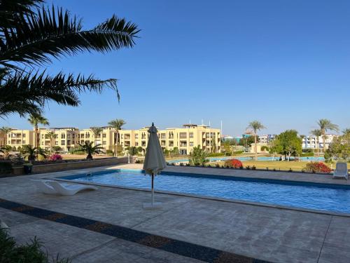 einen Regenschirm neben einem Pool in einem Resort in der Unterkunft Luxury studio for rent in Sharm El Sheikh
