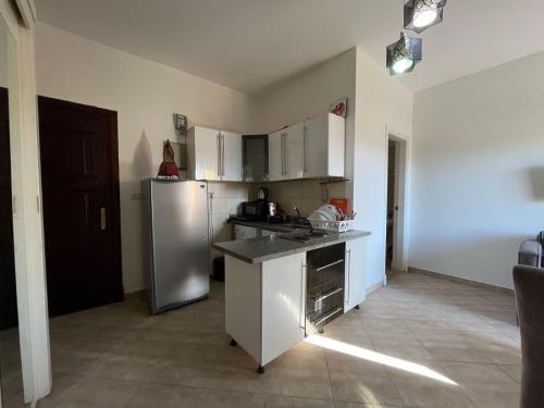 eine Küche mit einem Kühlschrank aus Edelstahl und weißen Schränken in der Unterkunft Luxury studio for rent in Sharm El Sheikh