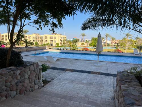 ein Pool mit Sonnenschirm und ein Gebäude in der Unterkunft Luxury studio for rent in Sharm El Sheikh