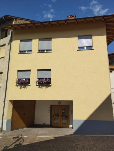 a yellow building with two windows and a door at Freddie house in Albiano