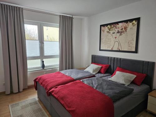 a bedroom with a bed with a red blanket at New Apartment mit Terrasse in Hannover