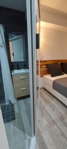 1 dormitorio con cama, lavabo y espejo en Villa Belle Vie - Climatisée & Piscine chauffée, en La Possession