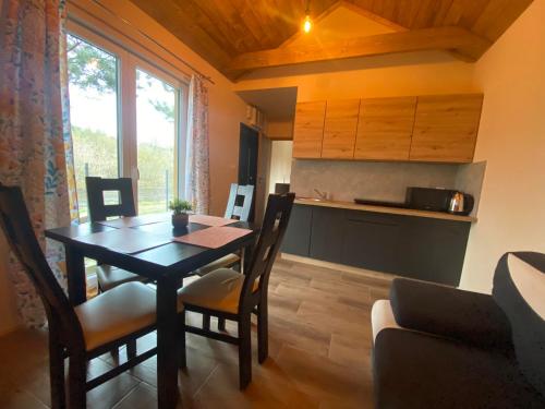 a kitchen and dining room with a table and chairs at Domek całoroczny nad rzeką Wkra in Pomiechówek