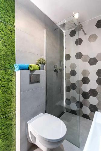 a bathroom with a toilet and a glass shower at Loftowe Pokoje in Góra Puławska