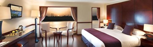 a hotel room with a large bed and a desk at NILE CRUISE ULTRA DELUXE in Aswan