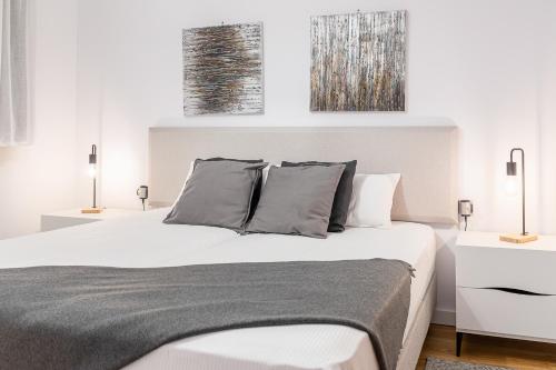 - une chambre avec un grand lit blanc et deux lampes dans l'établissement AndBnB I Apartamento con Terraza y Parking, à Arinsal