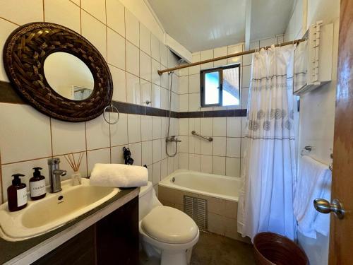 a bathroom with a sink and a toilet and a tub at PARAÍSO Sunset Bungallows in Hanga Roa