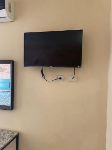 a flat screen tv hanging on a wall at HOTEL POSEIDON SUITES in Los Mochis
