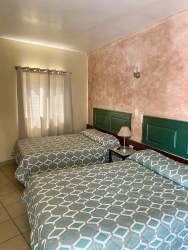 two beds in a room with two beds sidx sidx sidx at HOTEL POSEIDON SUITES in Los Mochis