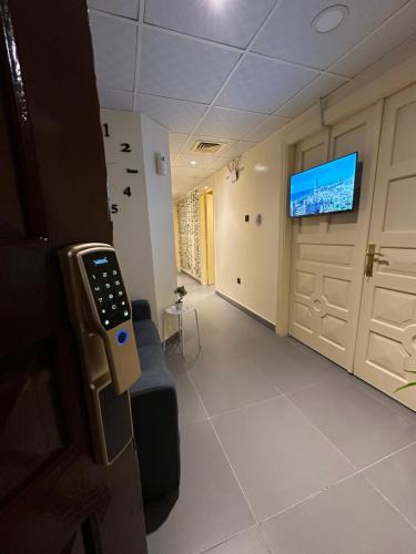 Cette chambre dispose d'une porte et d'une télévision murale. dans l'établissement Sunrise Inn by DSV Property, à Abu Dhabi