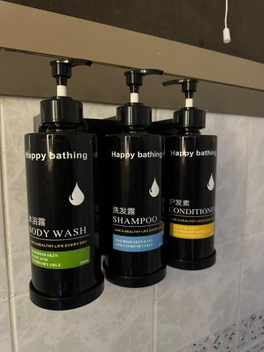 a group of three bottles of hair products on a shelf at Sunrise Inn by DSV Property in Abu Dhabi