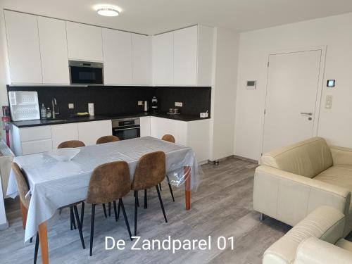 a kitchen and dining room with a table and chairs at De Zandparel in De Panne