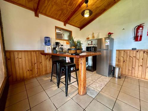 a kitchen with a wooden table and a refrigerator at PARAÍSO Sunset Bungallows in Hanga Roa