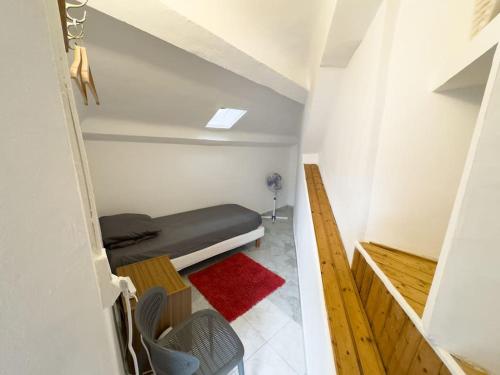 a small room with a bed and a red rug at Studio - vieux port in Marseille