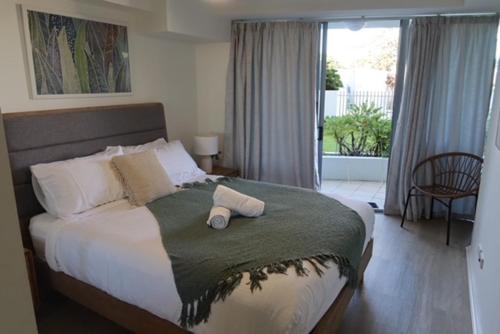 a bedroom with a large bed with two pillows on it at Ground Floor Luxury Oceanfront Apartment in Bargara