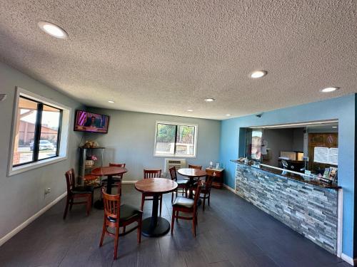 a restaurant with tables and chairs and a counter at American Inn-Alexander City in Alexander City