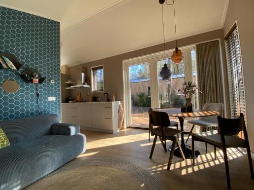 cocina y sala de estar con mesa y sillas en Tinyhouse Grasmus, en Nunspeet