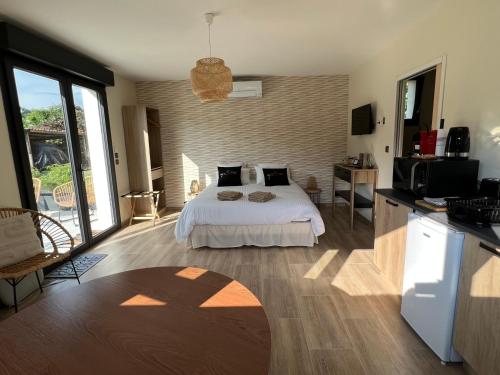 Cet appartement comprend une chambre avec un lit et une cuisine avec une télévision. dans l'établissement l'Atelier des rêves, à Morizès