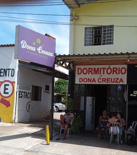 een groep mensen die buiten een gebouw in stoelen zitten bij Hotel da Creuza in Goiânia