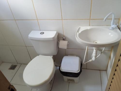 een kleine badkamer met een toilet en een wastafel bij Hotel da Creuza in Goiânia