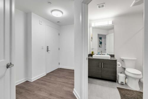 a white bathroom with a toilet and a sink at 2BR Furnished Apartment Near Nationals Park in Washington, D.C.