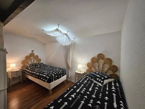 une chambre avec deux lits et un lustre dans l'établissement le loft bleu 3 étoiles 12 personnes, à Sablons