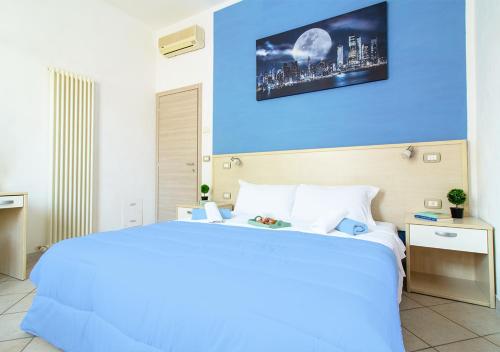 a bedroom with a large bed with a blue wall at Athena Rooms - Affittacamere in Bologna