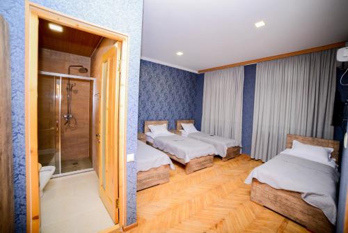 a room with two beds and a shower in it at Hotel Samta in Tsqaltubo