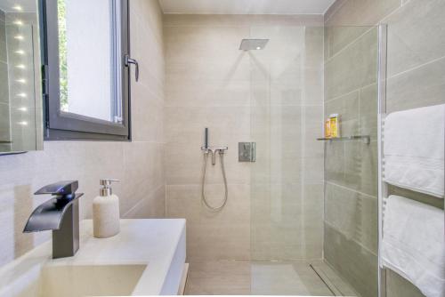 uma casa de banho com um chuveiro e um lavatório. em SUITE 20m2 DANS VILLA PISCINE JACUZZI em Gattières