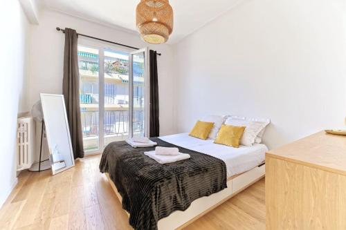 une chambre avec un lit et une grande fenêtre dans l'établissement CENTRE VILLE-SUPERBE APPARTEMENT DE 50 M2 - COSY AVEC TERRASSE -Wifi, à Nice