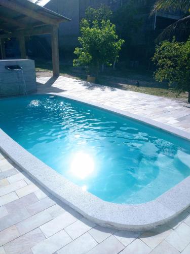 een zwembad met blauw water in een tuin bij Chácara com piscina em Itanhaém in Itanhaém