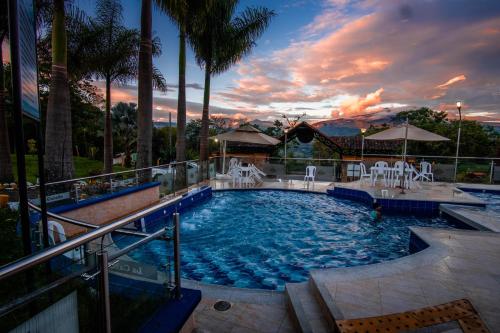 una piscina con sillas y una puesta de sol en La Cabaña Miraflores, en Miraflores