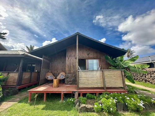 a house with a bench in front of it at PARAÍSO Sunset Bungalows in Hanga Roa