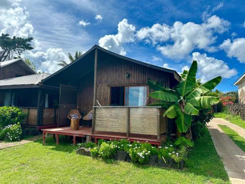 a house with a bench in front of it at PARAÍSO Sunset Bungalows in Hanga Roa