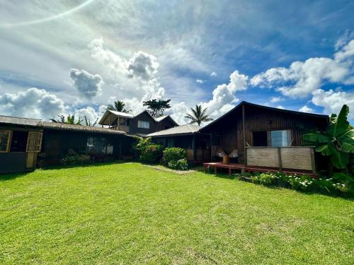 a house with a large yard in front of it at PARAÍSO Sunset Bungalows in Hanga Roa