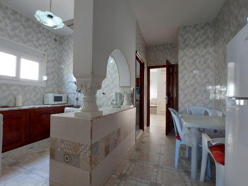 uma cozinha com um balcão e uma mesa com cadeiras em Nice Holiday Apartment Hammam Sousse em Hammam Sousse