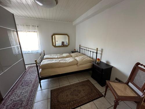1 dormitorio con cama, espejo y silla en Apartment58, en Wiehl