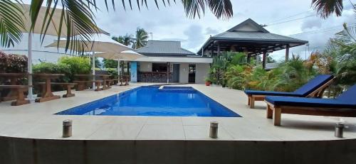 a swimming pool in front of a house at New Door Apartments in Nadi