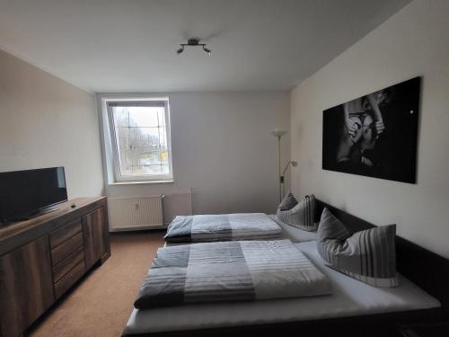 1 dormitorio con 2 camas y TV. en Apartment - Gästewohnung - Unterkunft Monteure, en Chemnitz