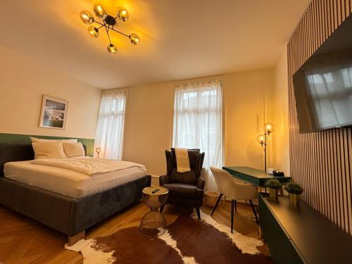 a bedroom with a bed and a desk and a chair at Apartments by DASBREITEHOTEL in Basel