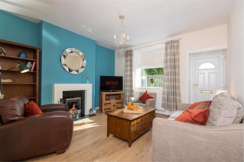 a living room with two couches and a tv at Miners cottage DH1 Bungalow Free Parking Longstay in Sheepscar
