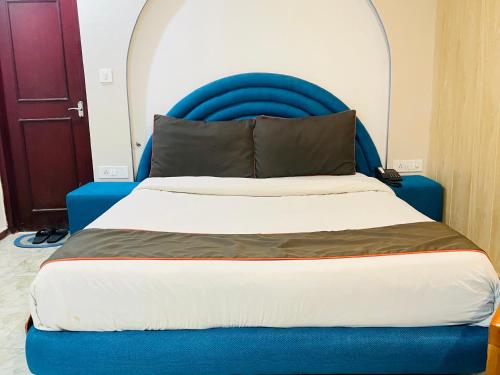 a bed with a blue headboard in a room at Royal Suites in Lucknow
