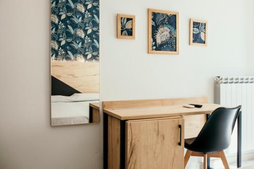 a desk and a chair next to a wall with paintings at Hotel Acquario in Vasto
