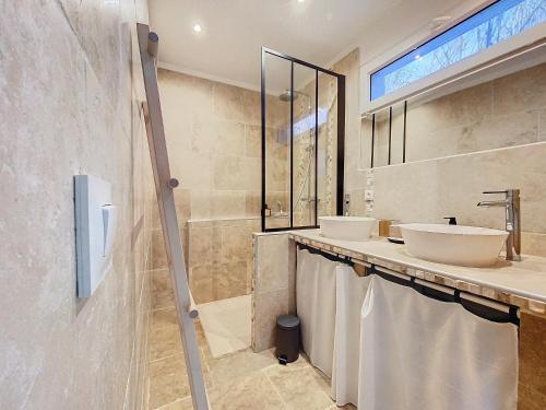 une salle de bain avec deux lavabos et deux miroirs dans l'établissement Le gîte des oliviers, à Sarrians