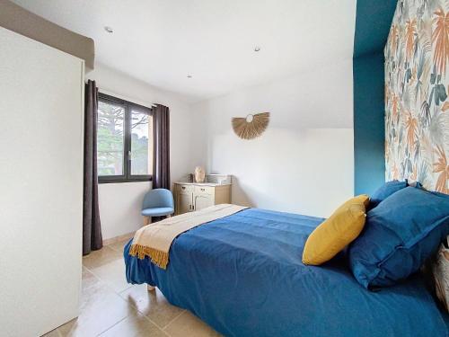 une chambre avec un lit bleu et une fenêtre dans l'établissement Le gîte des oliviers, à Sarrians
